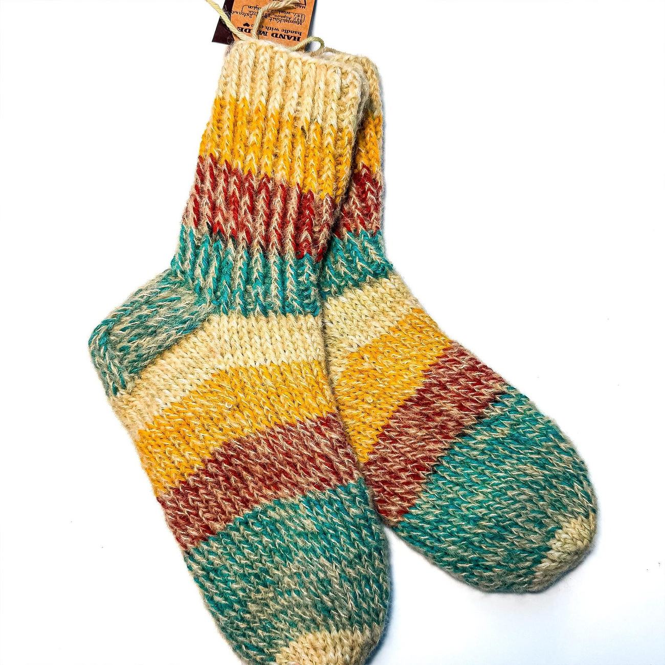 Chunky alpaca socks in gold, rust red and teal stripes on cream, with the handmade tag