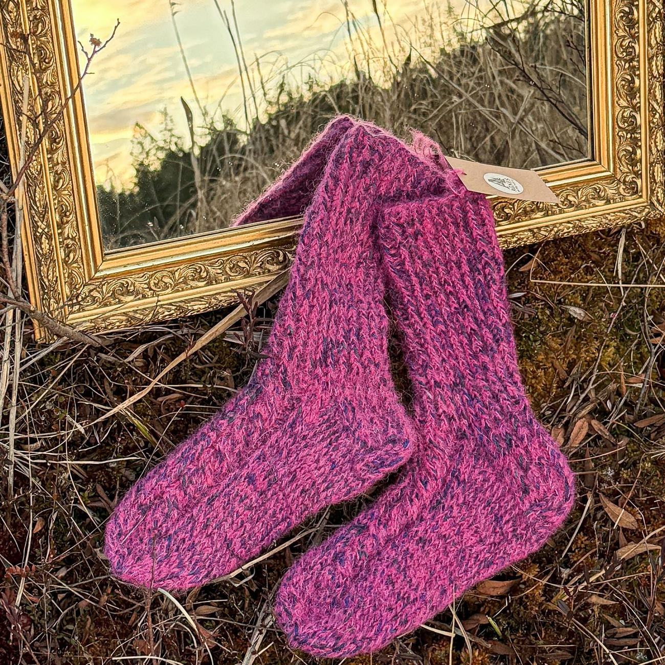 Deep magenta ribbed socks with navy flecks, hanging by the gilded mirror at sunset