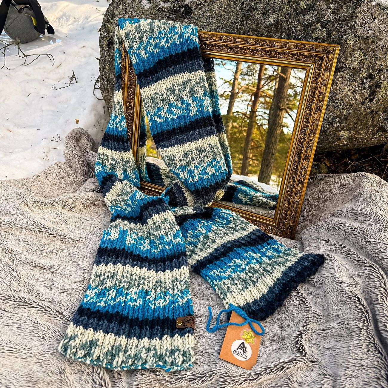 The Nordic blue scarf draped over the mirror frame in the snow